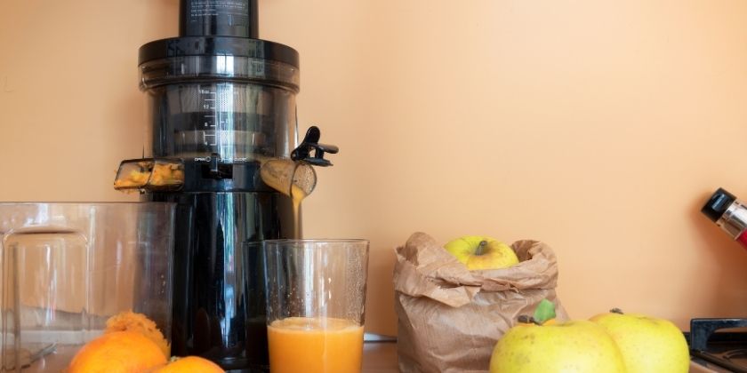 Estrattore in azione con mele e arance intorno